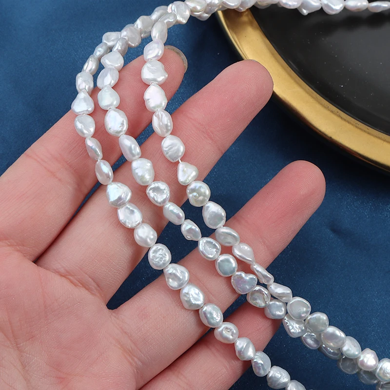 A strand of 5-6mm nucleus-free regenerated bead, broken silver and natural irregular pearls, approximately 39 cm in length.