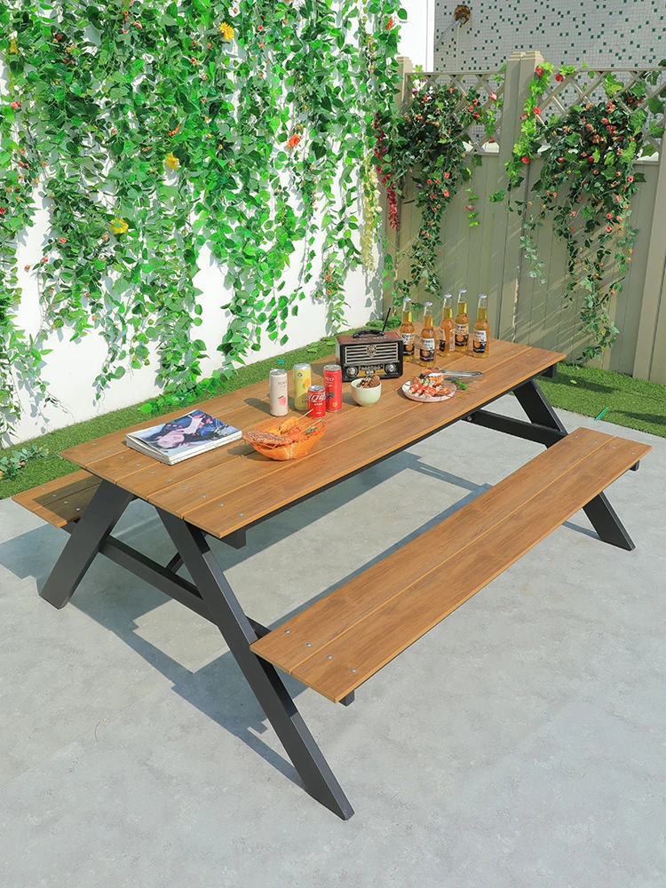 Long table and chairs outside the wrought iron long seat