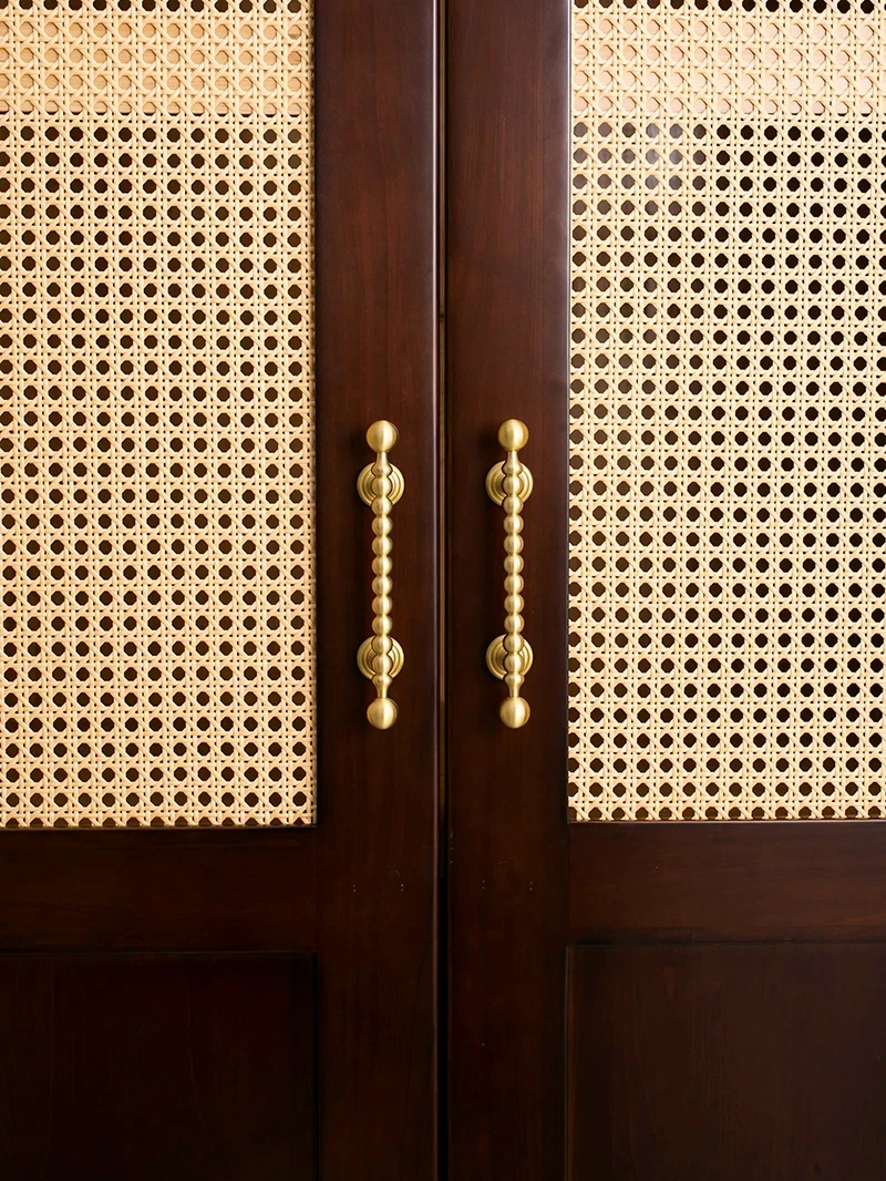 Brass beaded handles on dark wooden cane cabinet doors