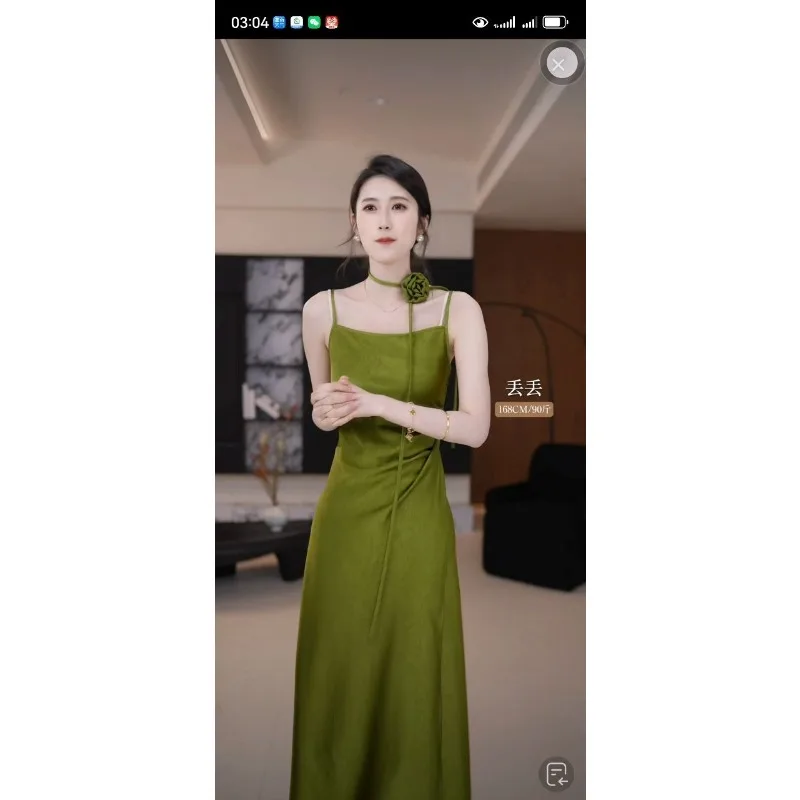 Damska sukienka maxi na ramiączkach spaghetti, z satyny w kolorze oliwkowej zieleni, z kwiatowym zdobieniem i marszczeniami, idealna na wieczorne przyjęcie.