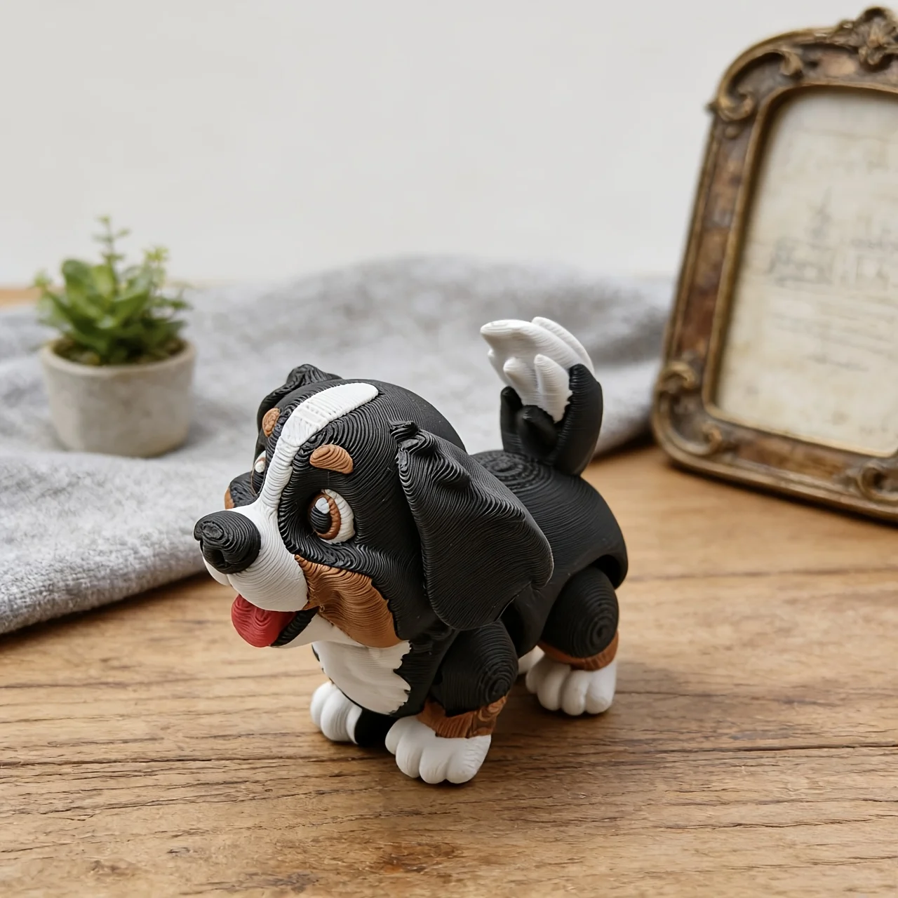 3D printed articulated Bernese Mountain Dog cub figurine with movable joints on a wooden table