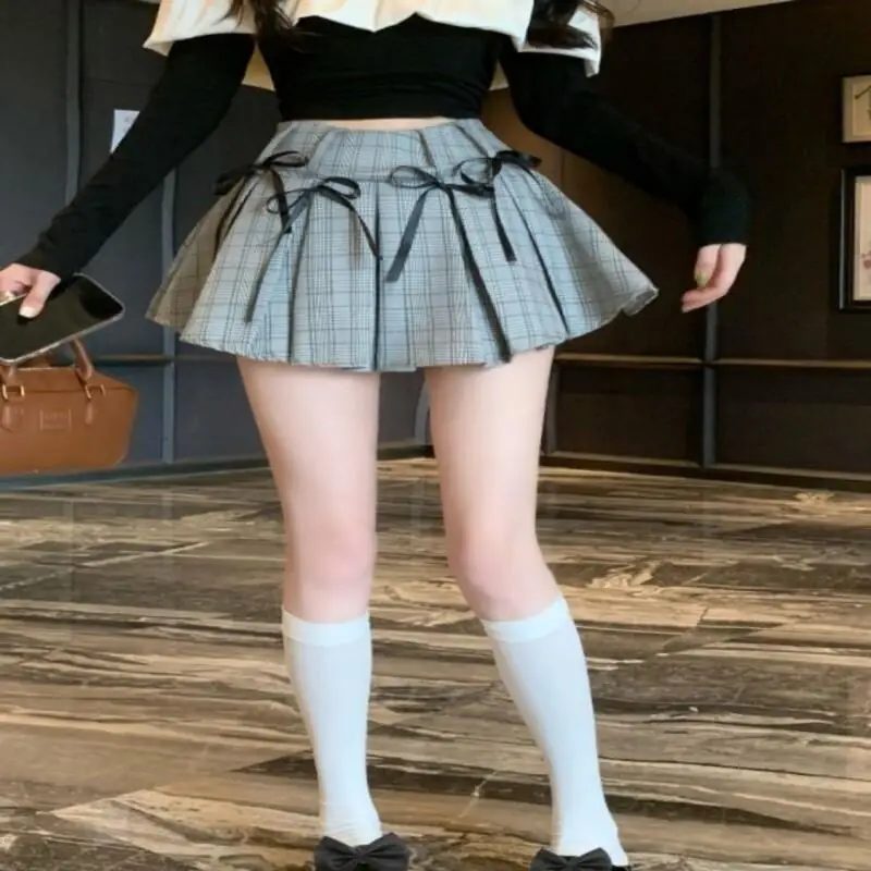 Słodki styl, francuski styl, krótka spódniczka, spódniczka z kokardą, plisowana spódniczka, wiosna i lato, dla studentek, modny trend, do noszenia podczas zakupów na świeżym powietrzu.