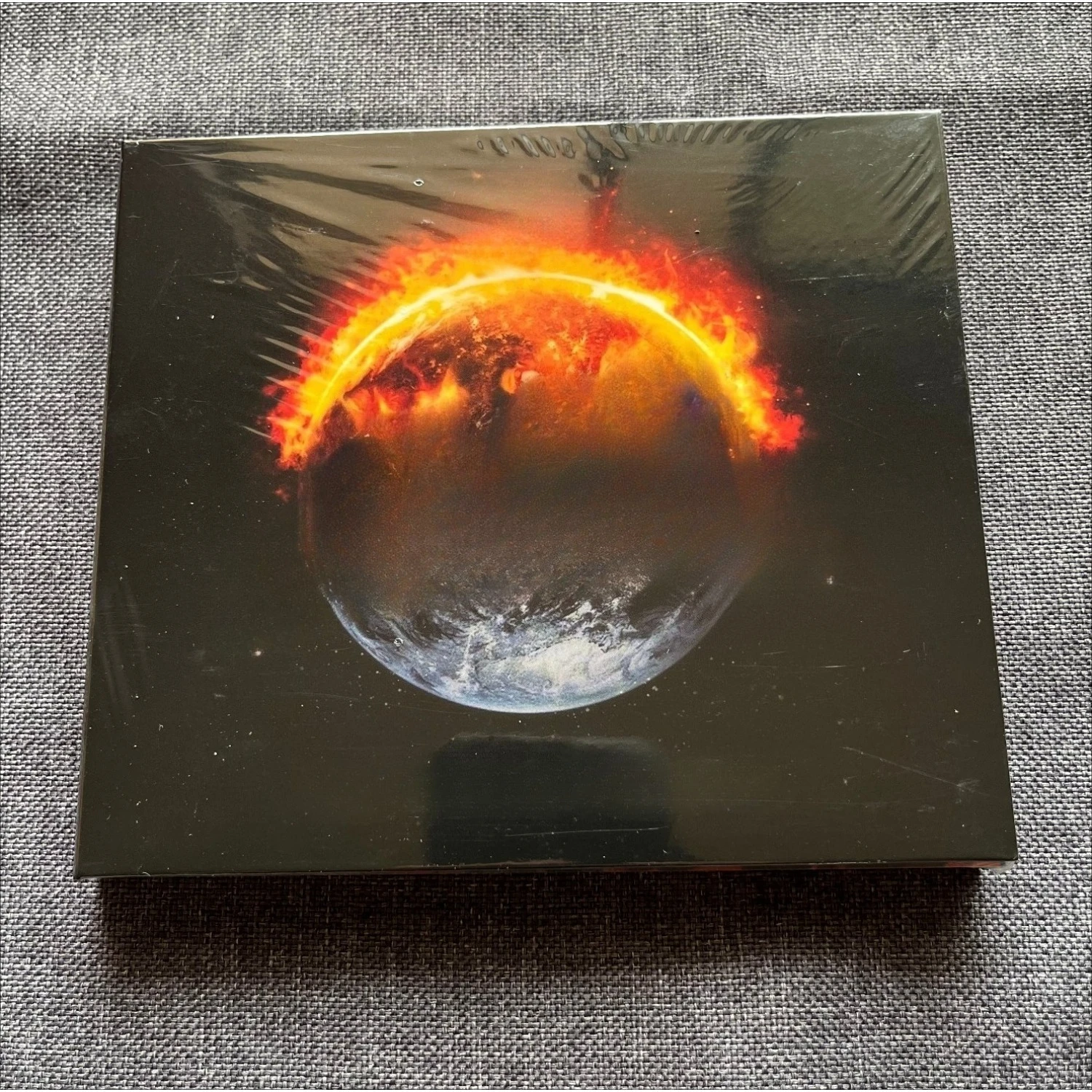 CD audio di un concerto di una famosa band di heavy metal, con copertina dal design vintage ispirato all’arte spaziale di Burning Planet, disco di mus