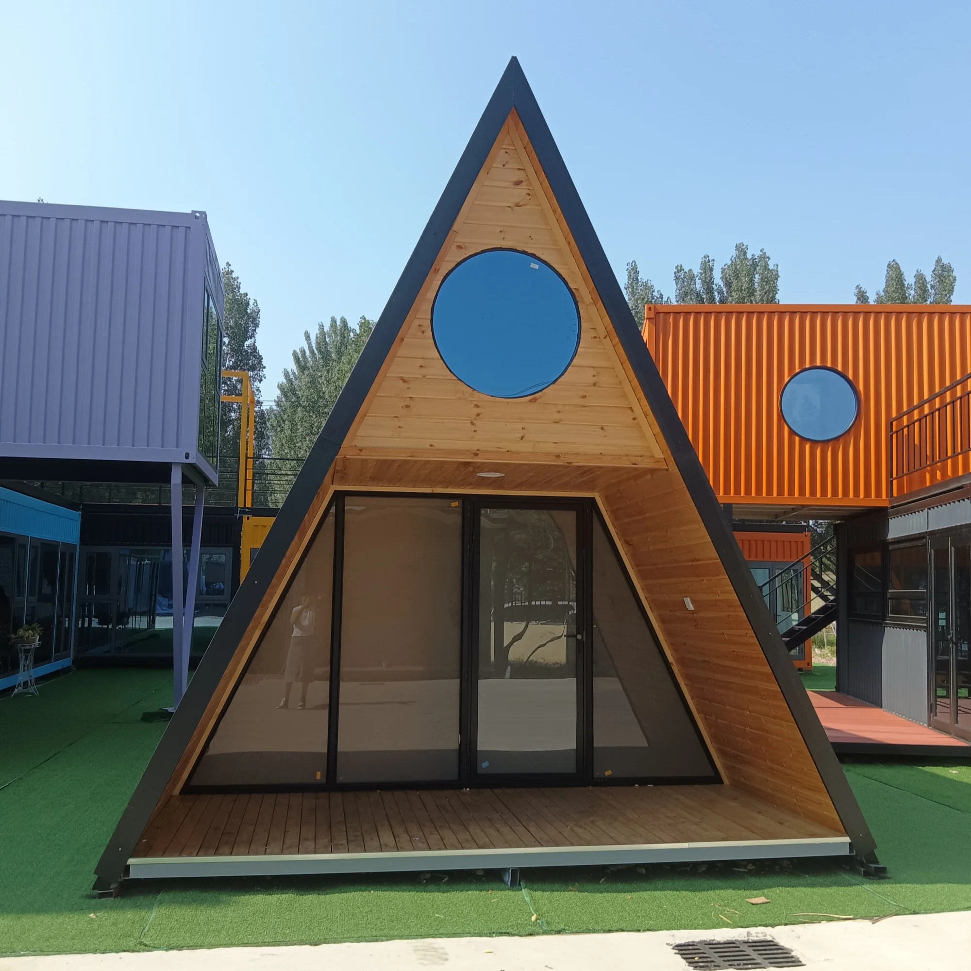 Casa de madera triangular de dos pisos con dormitorio y baño