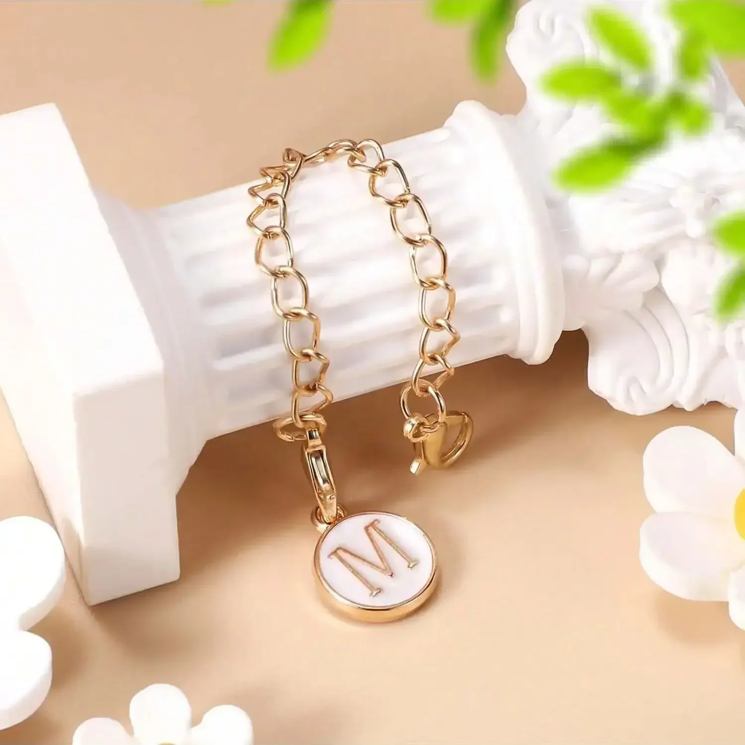 A Stanley letter charm accessory with a minimalist modern cup nameplate charm recognition letter charm chain in white