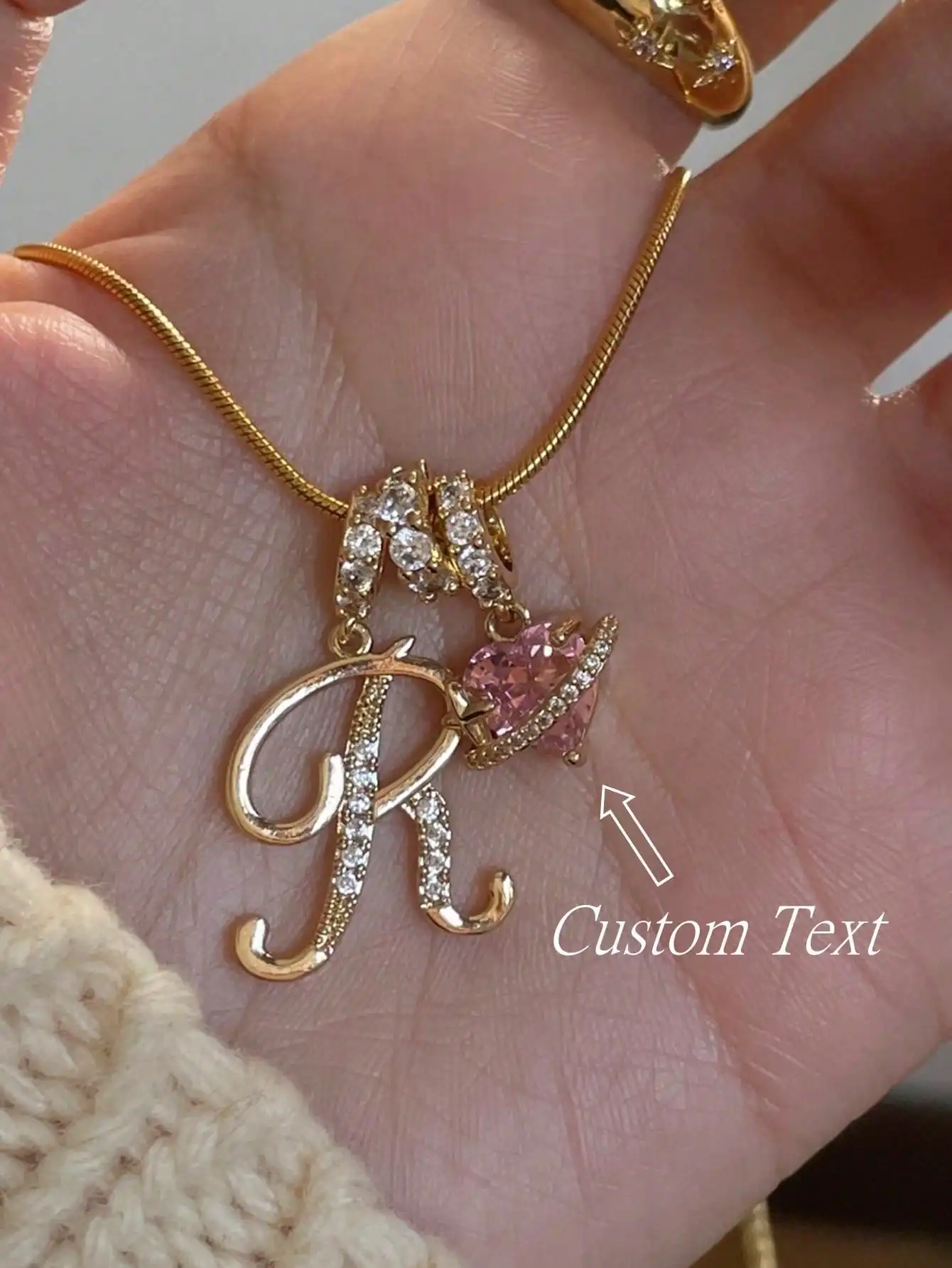 

Золотистое ожерелье с подвеской в виде буквы «R» и розовым сердечком из фианитов, цепочка-змейка