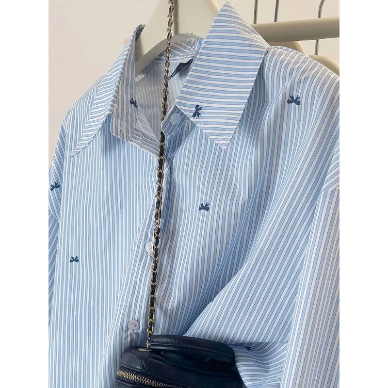 เสื้อเชิ้ตลายทางสีฟ้า เสื้อเชิ้ตแขนยาวพิมพ์ลายโบว์สไตล์เกาหลีลำลองสำหรับผู้หญิง