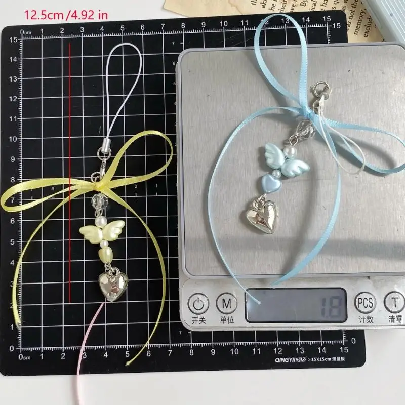 A52E Charm-Handykette in Herzform aus Silber, verziert mit Engelsflügel und Band – Detail 6