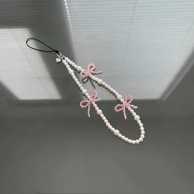 

Розовый ремешок-шарм с жемчугом и бантом для девочек, для чехлов для телефонов, сумок, пеналов, универсальный аксессуар, простой и изящный.