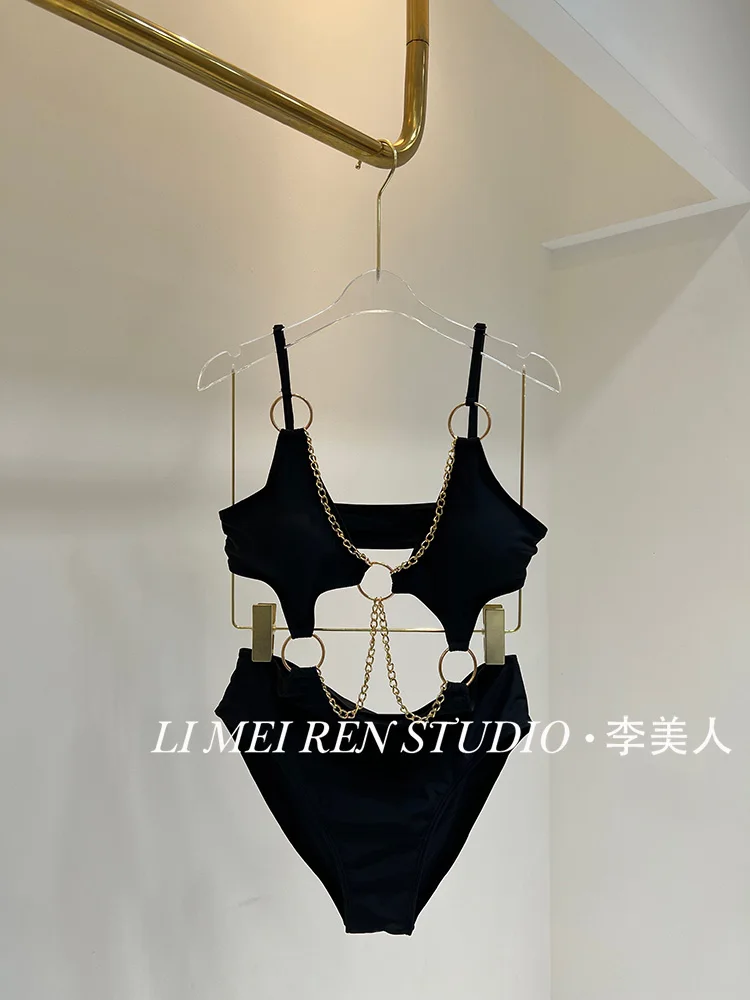 

Новый стиль пикантной девушки собирает высококачественный цельный купальник с черной металлической цепочкой