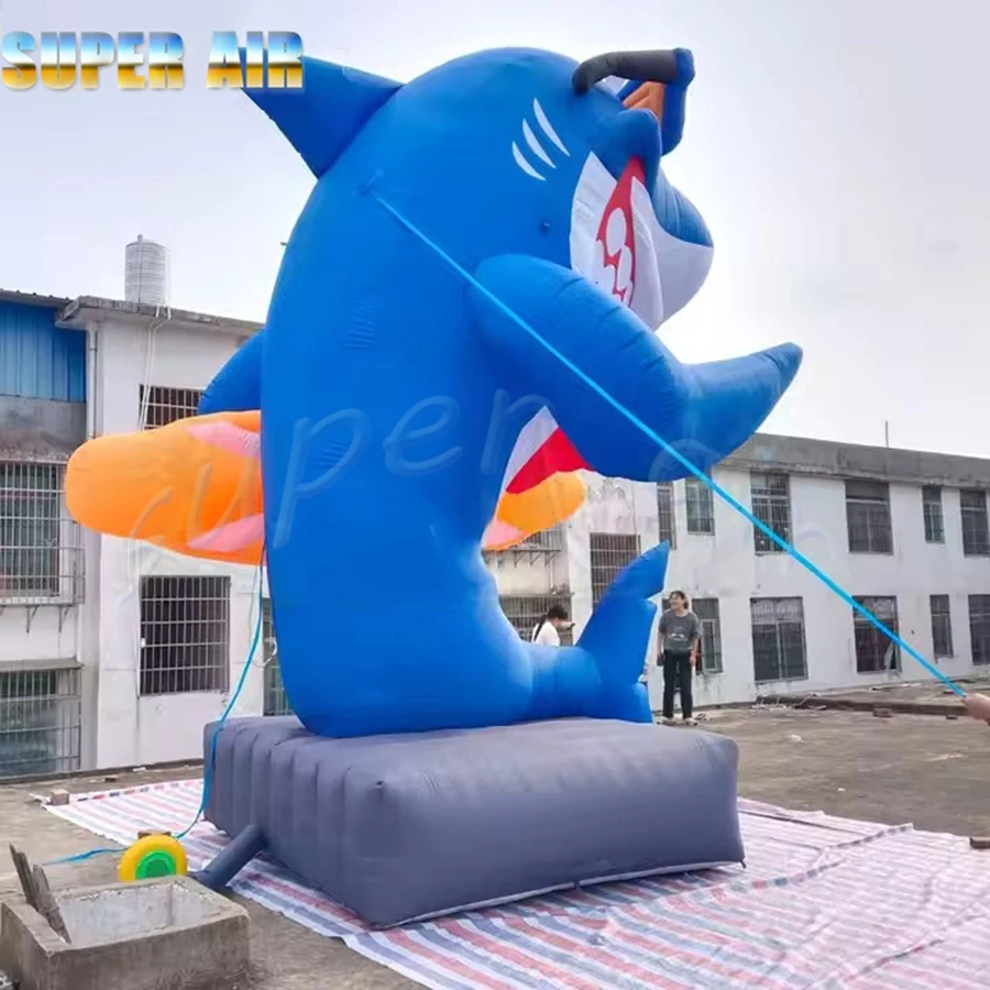 Hermoso modelo de organismo marino, sonrisa, tiburón inflable, sostiene el tobogán y observación de gafas de sol a la venta