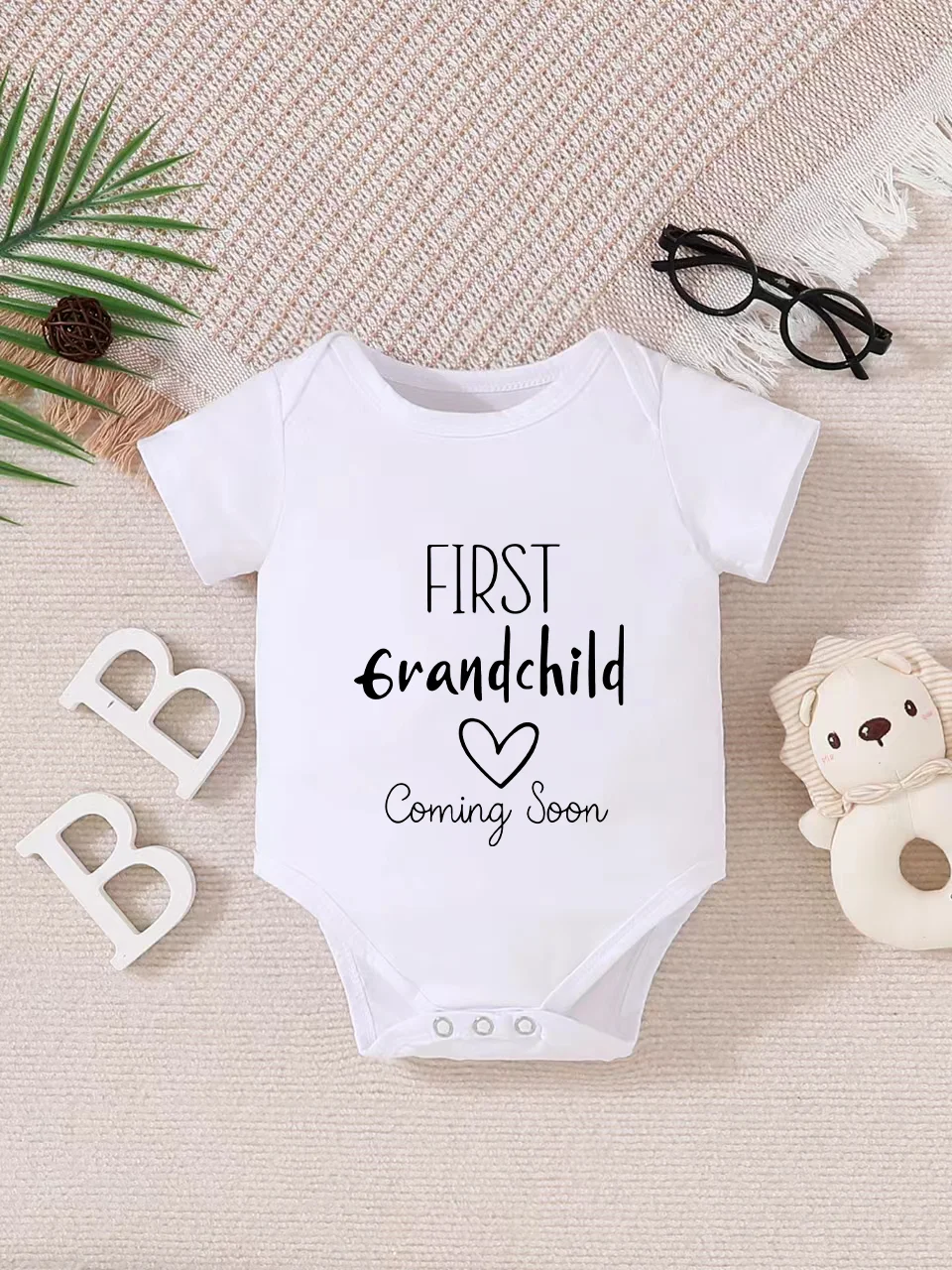 Playful letter-printed baby short-sleeve triangle bodysuit. Button closure for easy dressing