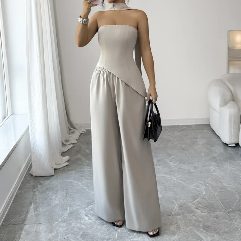 

Женский элегантный комплект из двух предметов: топ без рукавов и бретелек с асимметричным кроем и свободные брюки. Летний повседневный сексуальный облегающий костюм для ежедневных поездок на работу.