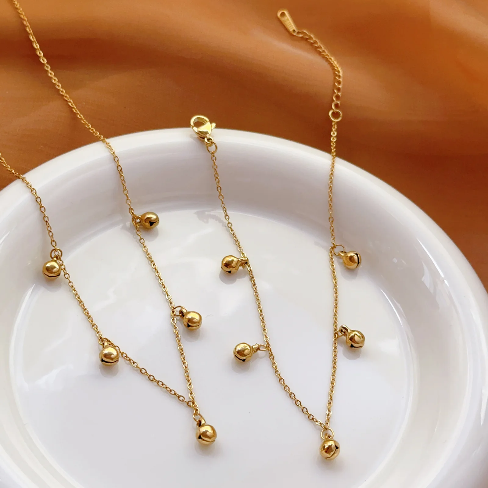

Одна и та же цепочка-колокольчик на шею для женщин: модная, не выцветающая, универсальная, с золотыми бусинами, подчеркивающая ключицы.
