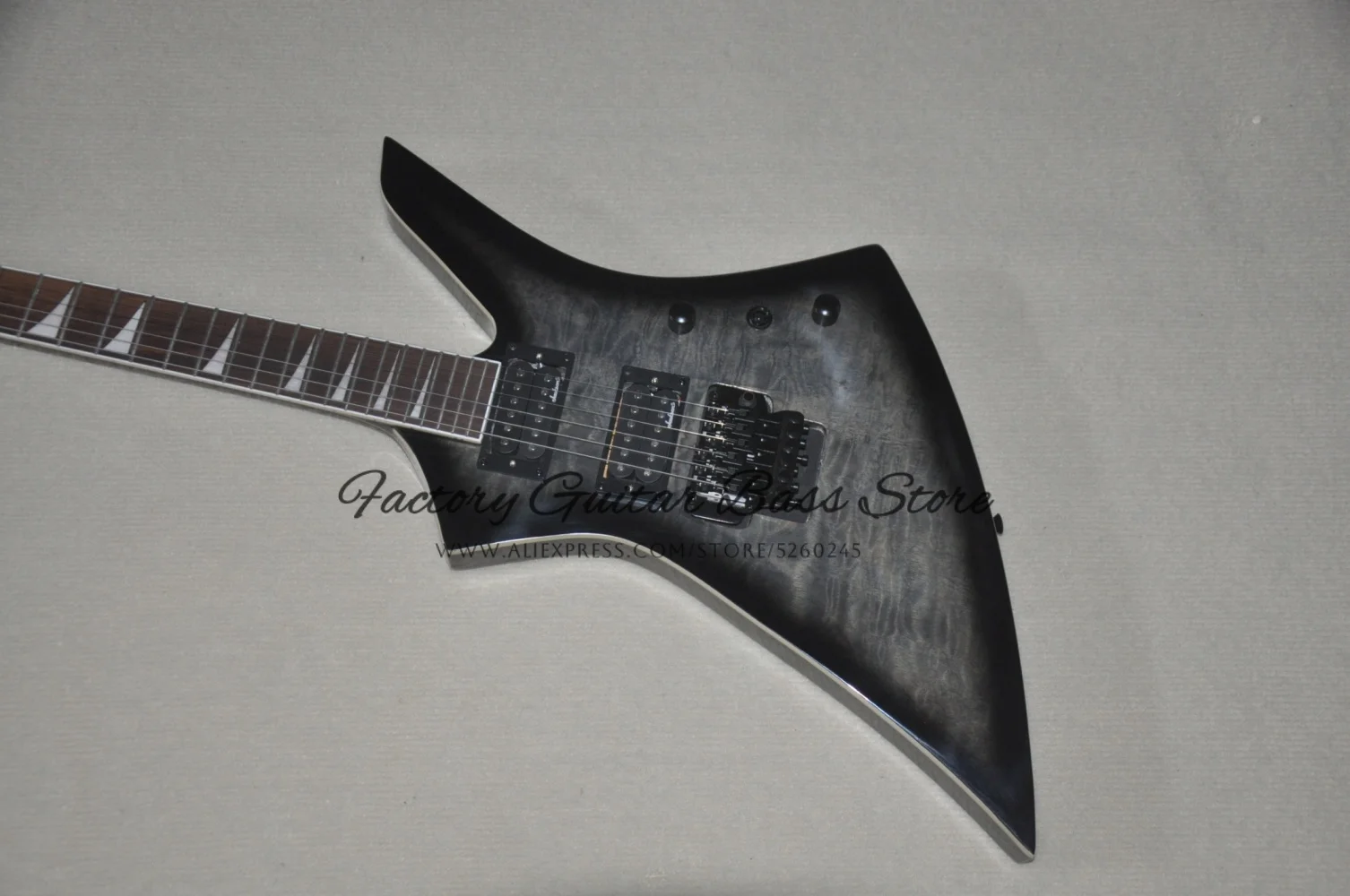 In stock for sale. Black guitar with tremolo bridge, flamed maple top, white binding, HH pickups, black tuner.