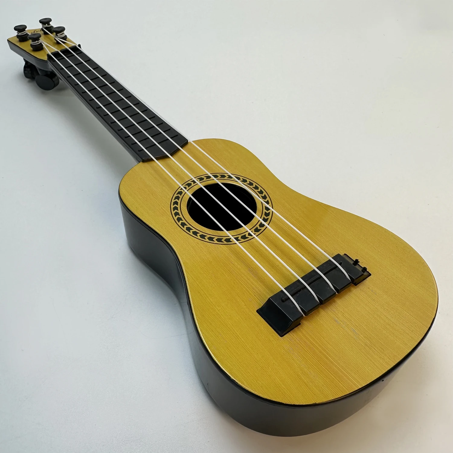 Music-orientated children's guitar toy that can be played with a pick to imitate basic musical instruments, resembling a ukulele