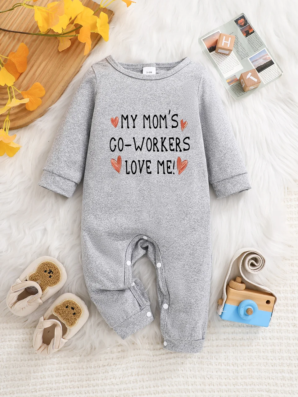 A baby long-sleeved onesie with interesting letter prints. It features a buttoned design for easy putting on and taking off