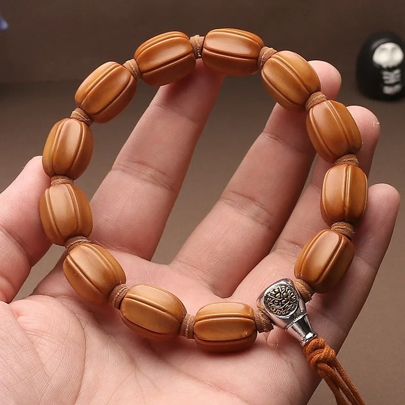 Hand-carved olive pit bracelet, single-strand, featuring a black tortoise charm, aged oil finish, and a three-piece accessory se