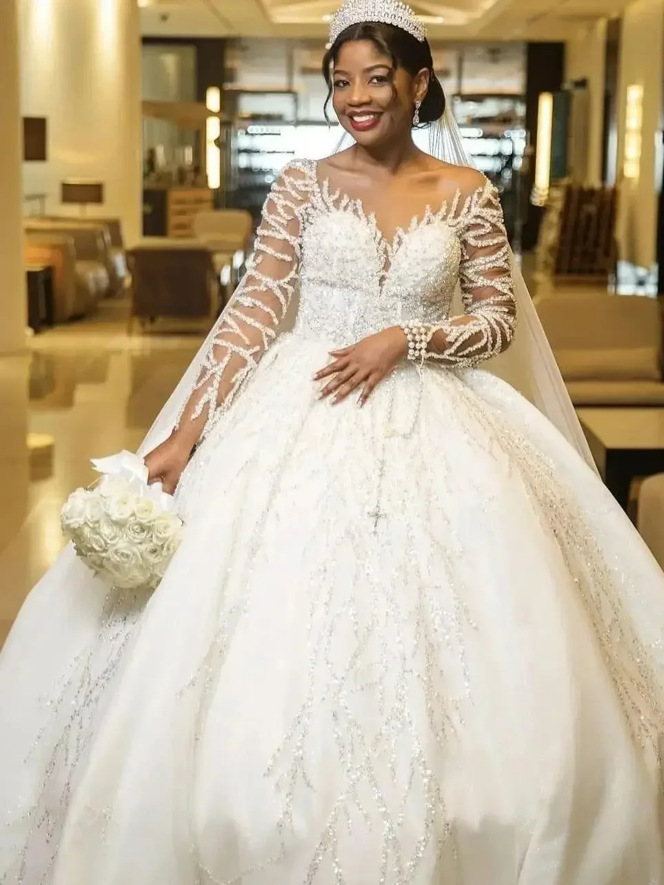 ชุดแต่งงานเจน แอร์ แบบคอวีประดับลูกปัดและเลื่อมวิบวับ พร้อมชายกระโปรงยาวแบบลากพื้น แขนยาว