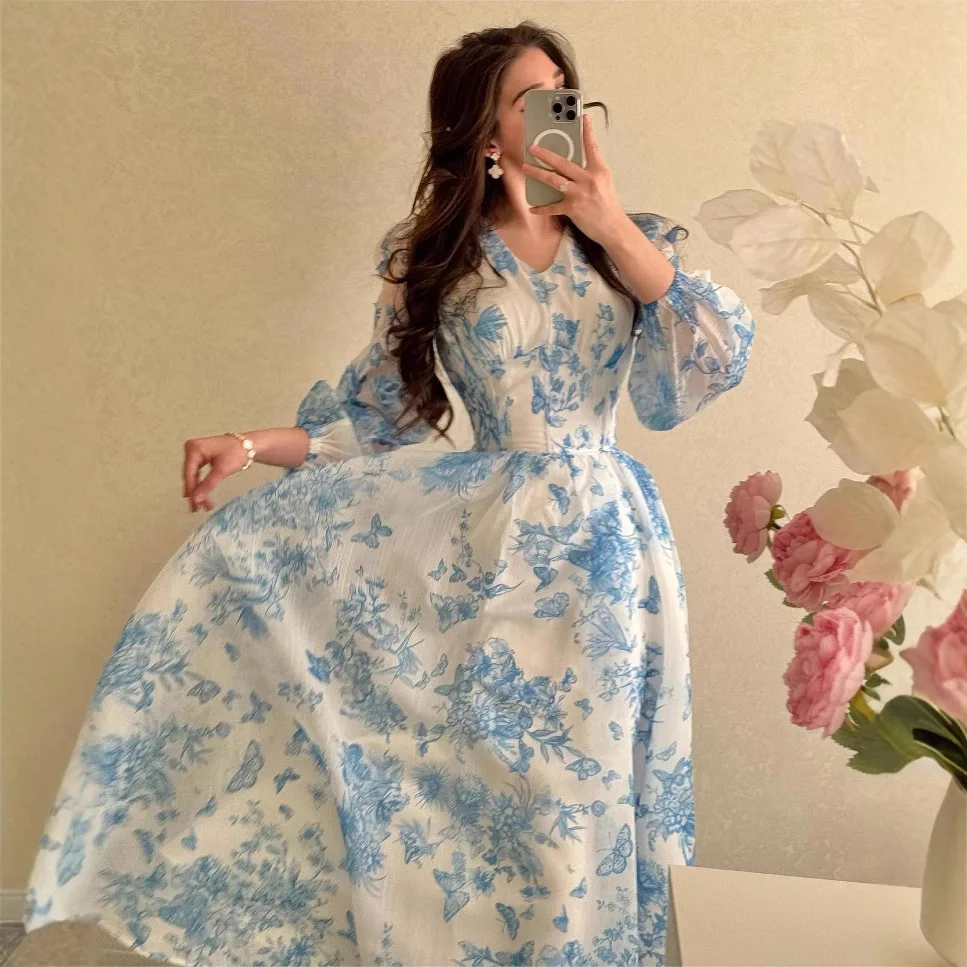 2025, neues Damen-Kleid mit blauem und weißem Blumendruck, V-Ausschnitt, langen Ärmeln, schmal geschnittenes langes Pendelkleid im französischen Stil, elegantes Urlaubsmodell