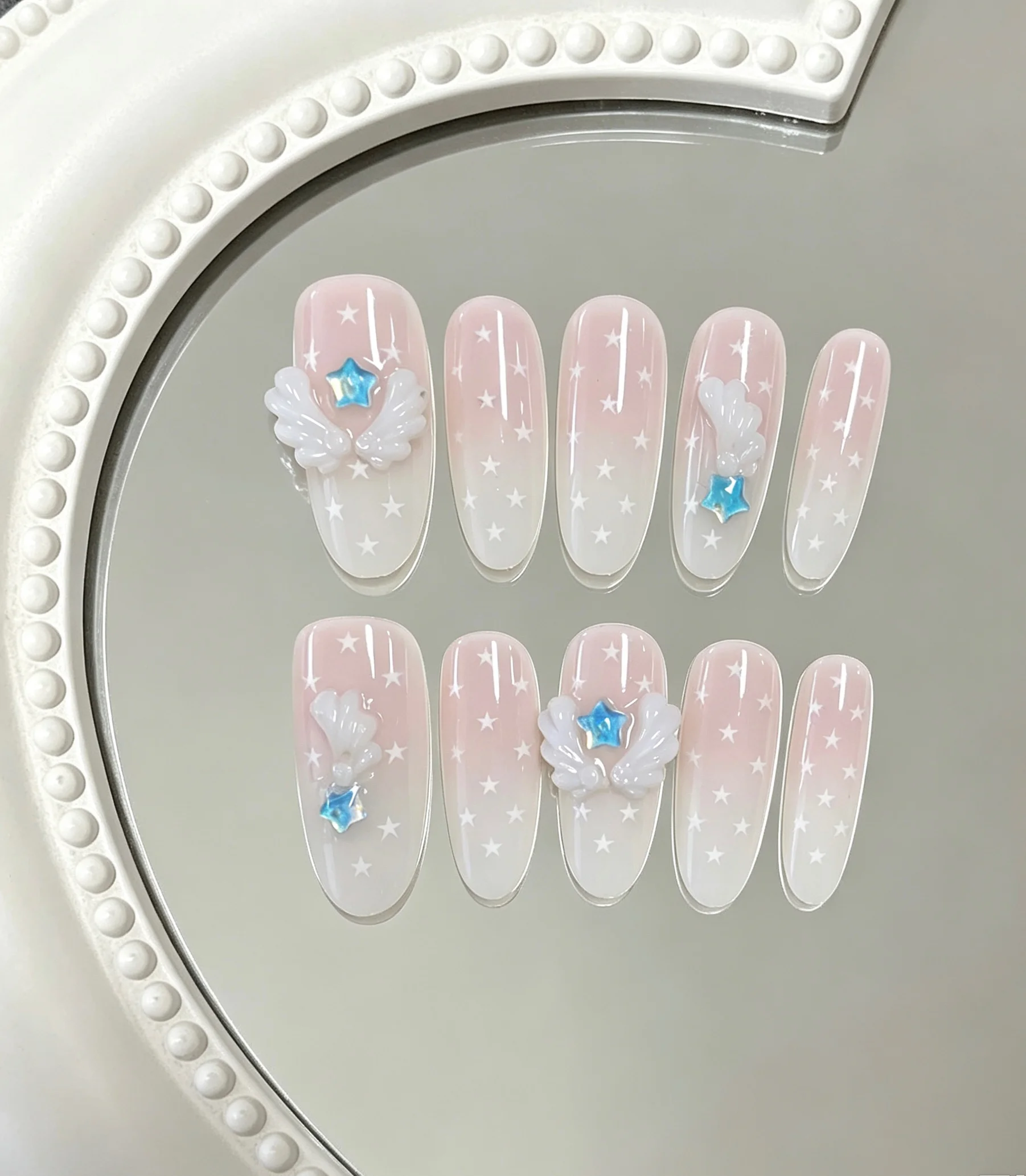 10-Piece Set of Pink and White Gradient Star Angel Wing Long Oval Press-On Nails, Light and Airy, Full of a Dreamy Girlish Vibe; Accessories Are Symmetrically Arranged, Simple yet Highly Memorable, Sweet Without Being Too Cloying.