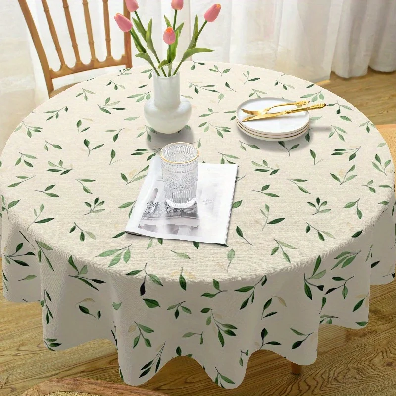 One round French tablecloth, made of polyester material, with a design of green leaves.