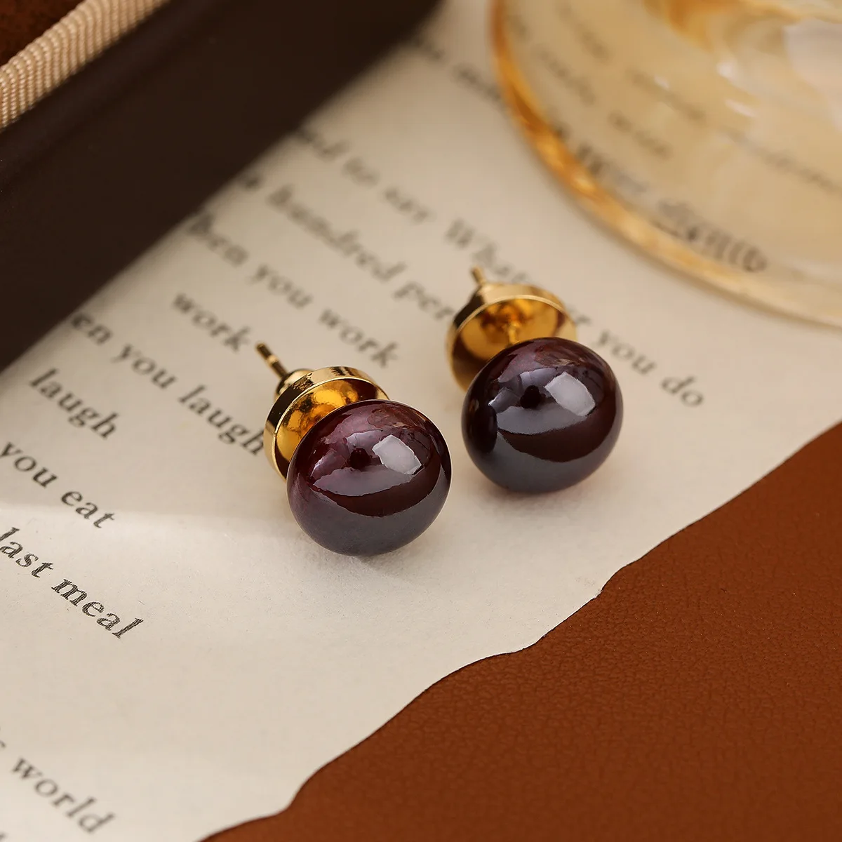 Luxury and niche high-end purple-hued red pearl stud earrings with a retro port style, small round earrings set in ear jewelry.