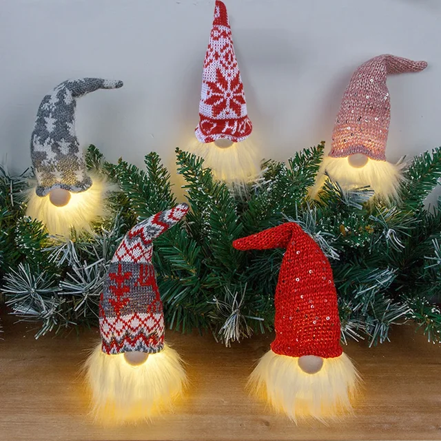 Set of glowing Christmas gnome decorations with knitted hats and warm LED beards in festive colours