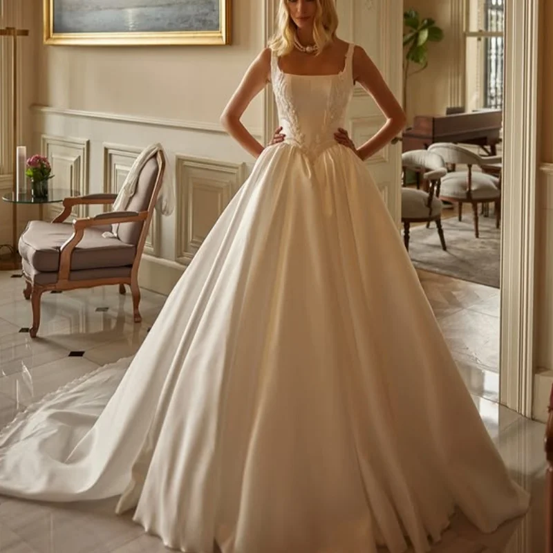 Satynowe suknie ślubne w kolorze kości słoniowej z aplikacjami, z odkrytymi ramionami, spódnica typu A, aplikacje kwiatowe, suknie ślubne szyte na miarę.