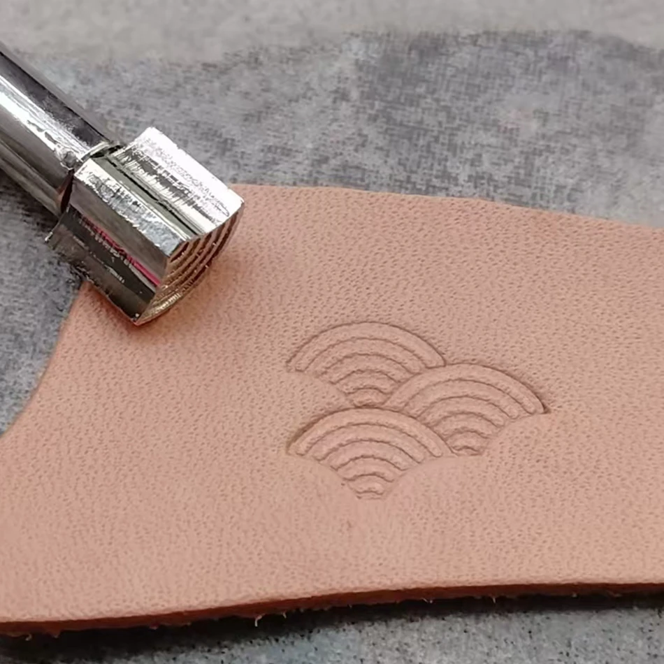 

Precision steel engraving and embossing tools for hand-sewn leather craftsmanship, featuring ocean wave decorative patterns.