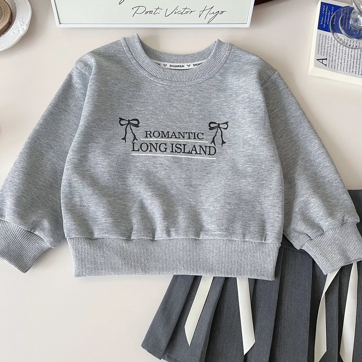 Komplet ubrań dla dzieci na jesień i zimę 2025, nowy styl koreański, dziewczęcy, w stylu zagranicznym, bluza z kapturem z kokardą, słodka krótka spódniczka, dwuczęściowy zestaw.