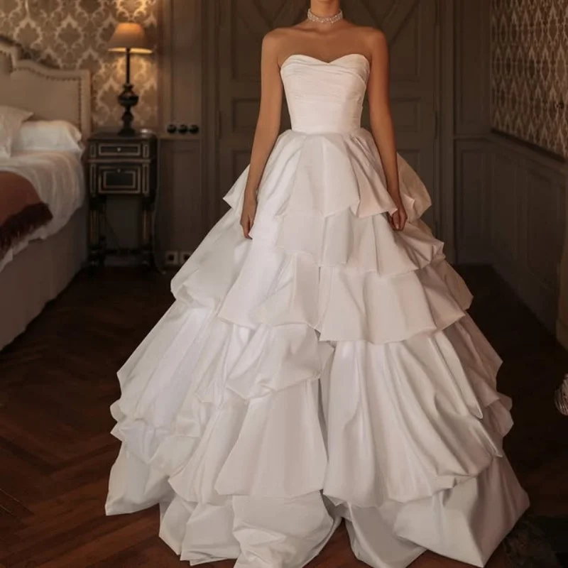 Abiti da sposa con applicazioni in raso bianco di abiti da sposa con decalcomania a strati senza maniche con spalle scoperte realizzati su misura