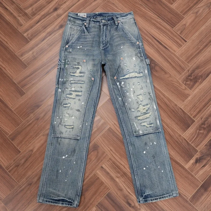 Men's high-end trendy ripped and patched jeans, heavy-duty distressed with paint splatter, vintage blue denim, fashionable men's