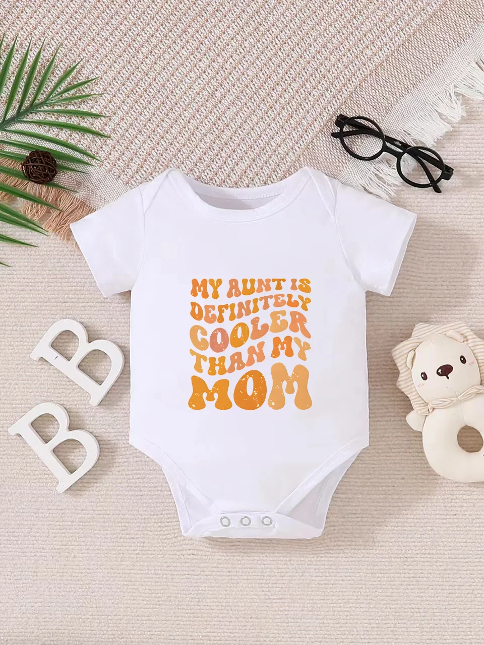 Playful letter-printed baby short-sleeve triangle bodysuit. Button closure for easy dressing