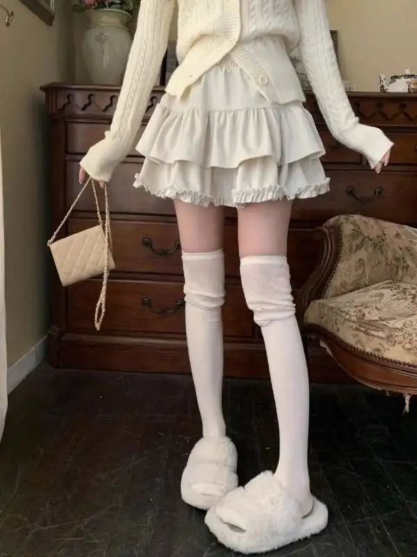 تنورة منفوشة للنساء شتاء 2025 جديدة بيضاء عالية الخصر نحيفة على شكل كعكة بتصميم خشبي