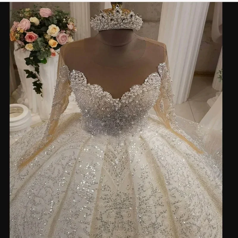 ชุดแต่งงานเจ้าสาวแบบยาว แขนยาว ประดับลูกปัดวิบวับ คอเสื้อซีทรู ดีไซน์หรูหรา  แบบสั่งตัดพิเศษ