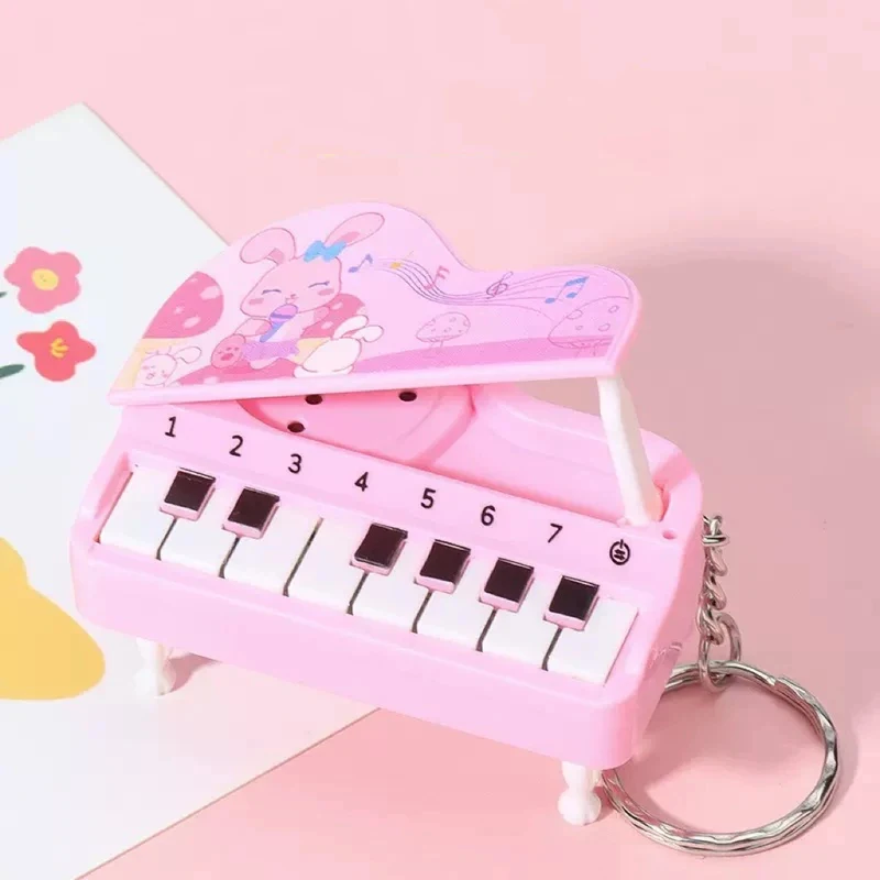 Un porte-clés mignon et miniature en forme de piano de bureau qui sert également de machine de jeu musicale colorée. C'est un jouet éducatif amusant et idéal