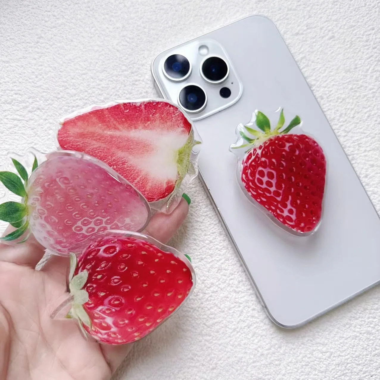 

Держатель для телефона в виде клубники из акрила с простым декором и клейкой подставкой-попсокетом.