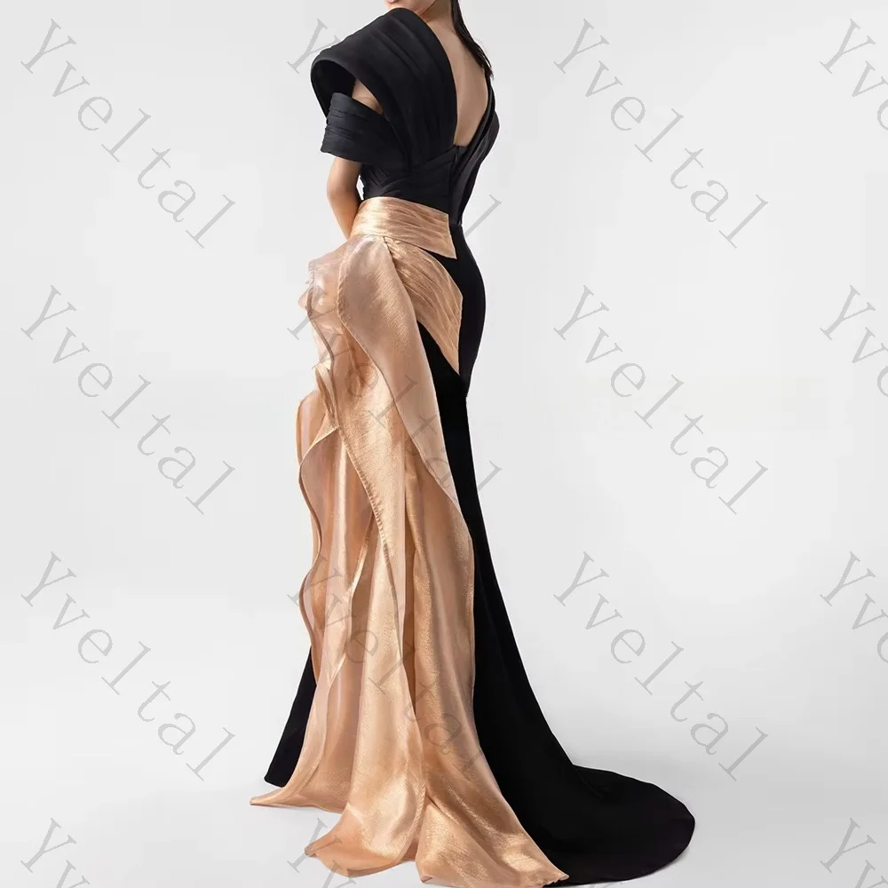 Vestido de noche de corte sirena con escote cuadrado, de color negro y con un elegante fajín de organza dorada, ideal para invitadas a una boda. Diseño personalizado para mujer.