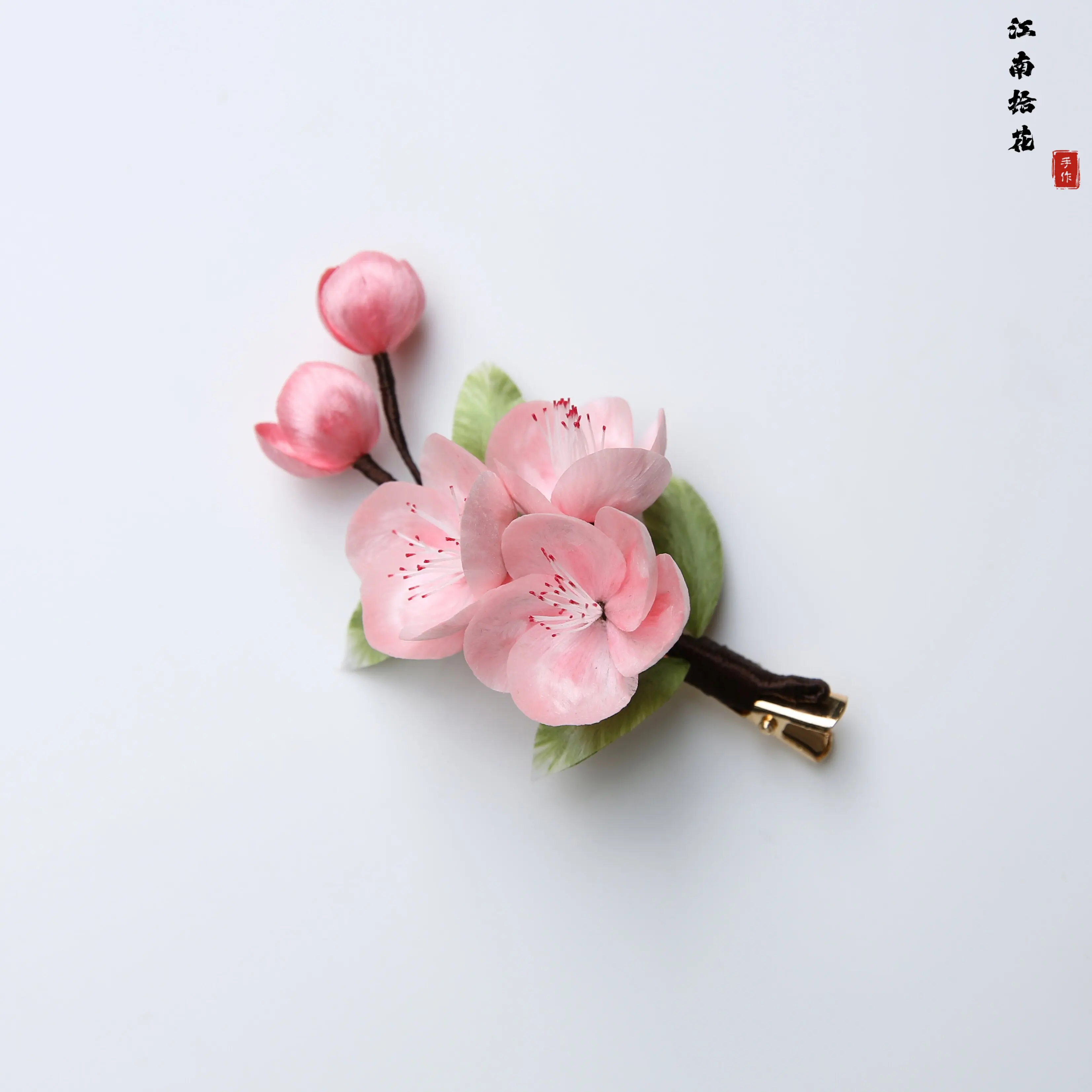 上品なピンク色の桃の花柄シルクベルベット製ヘアクリップ。無形文化遺産に指定された手仕事による工芸品。普段使いに最適なヘアアクセサリー。