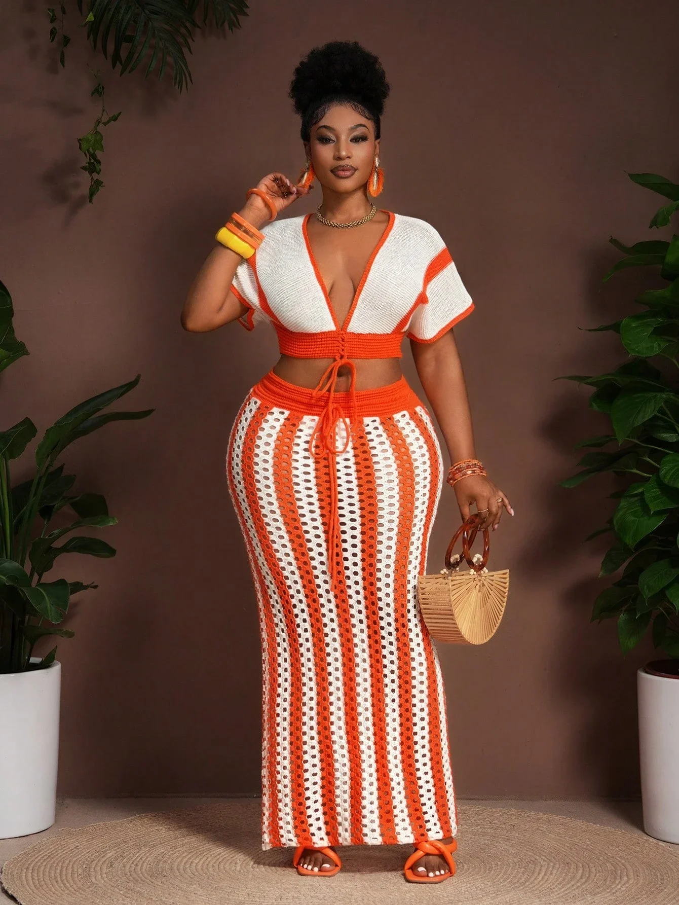 

Женский комплект из двух предметов больших размеров: вязаный кроп-топ с V-образным вырезом и завязками спереди, а также длинная полосатая юбка. Сексуальный комплект для отдыха.