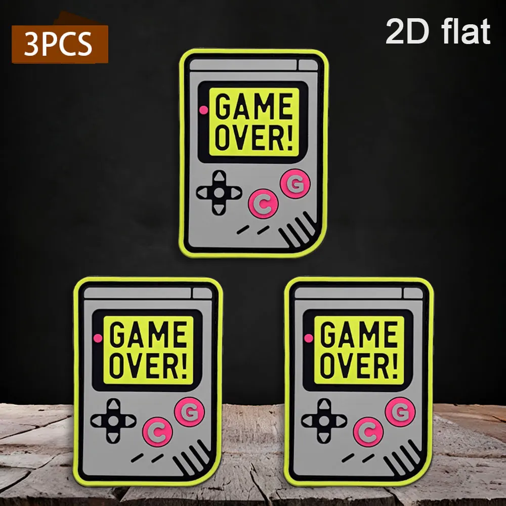 Available in 1pc/2pcs/3pcs options. 2D retro handheld game console PVC rubber. Comes with GAME OVER embossed patches in yellow, gray, and black colors. Waterproof, wear-resistant, and not easy to fade. Suitable for gaming enthusiasts as a trendy decorative patch for gaming jackets, work bags, and functional vests