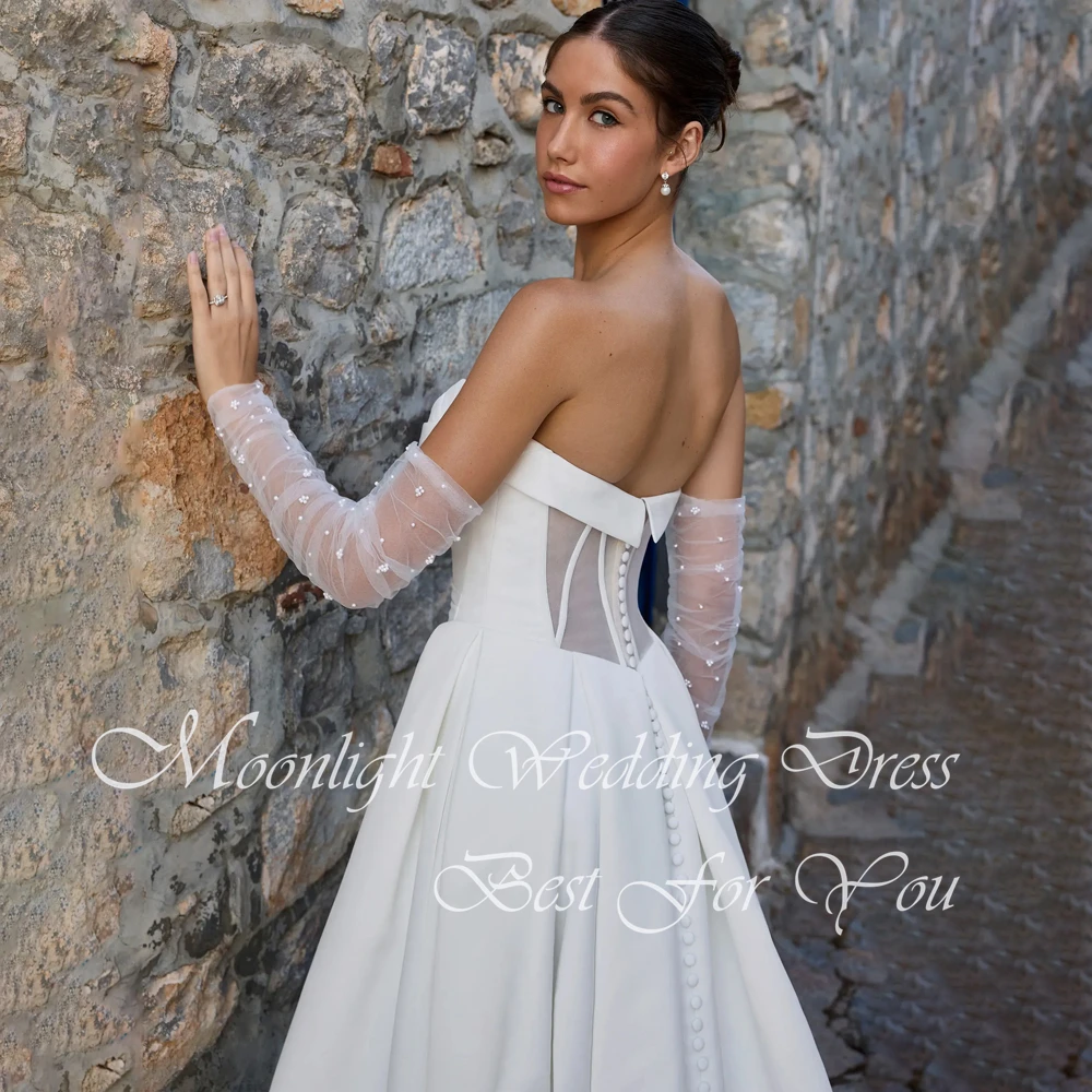 Klasyczna suknia ślubna w kształcie litery A z plisami, dekoltem w serduszko, wysokim rozcięciem z boku, odkrytymi ramionami, odkrytymi plecami, trenem zamiatającym i możliwością personalizacji.