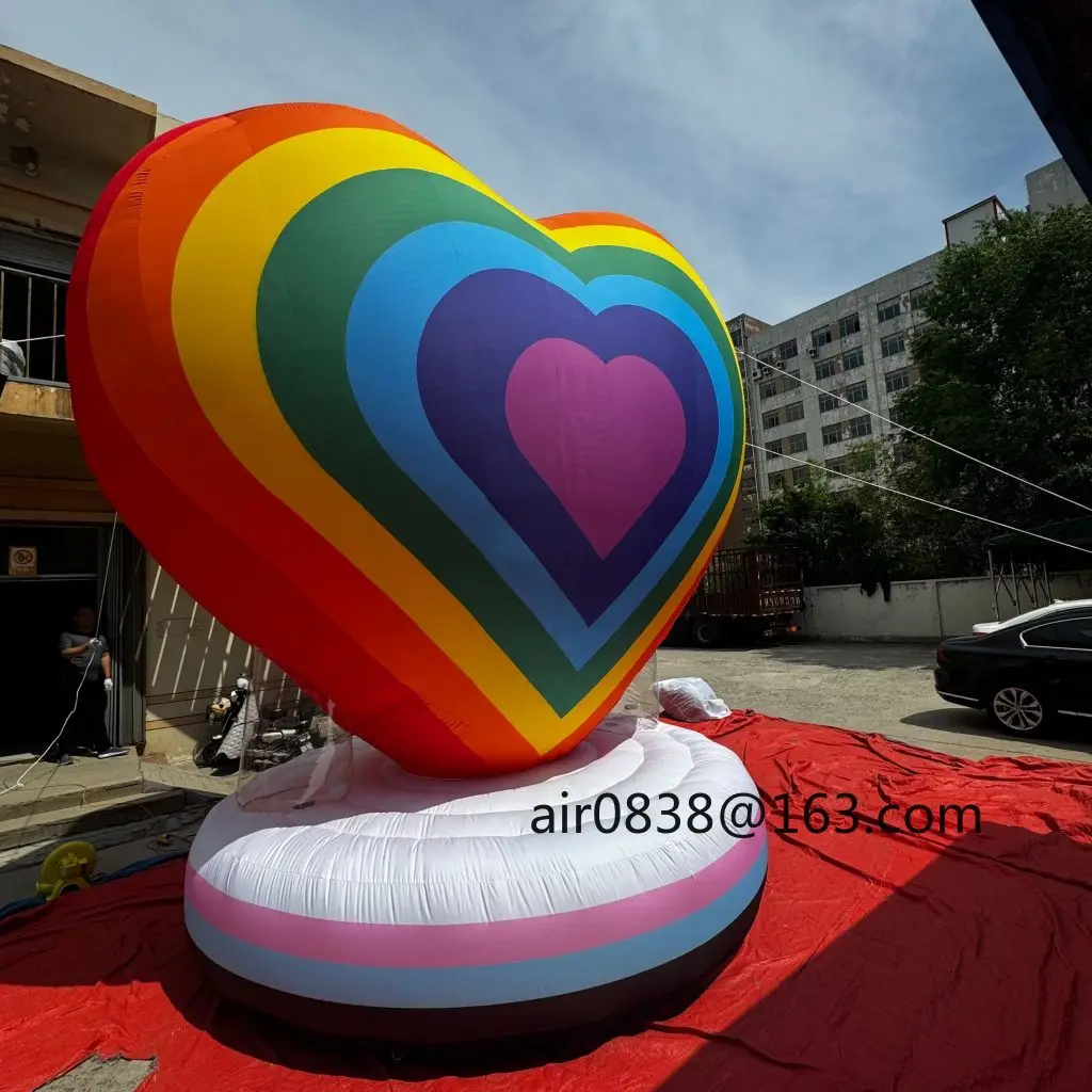 カラフルな虹色の膨らませるハート型、丸い台座付き巨大な膨らませるハート型モデル、結婚式パーティーイベントの装飾に