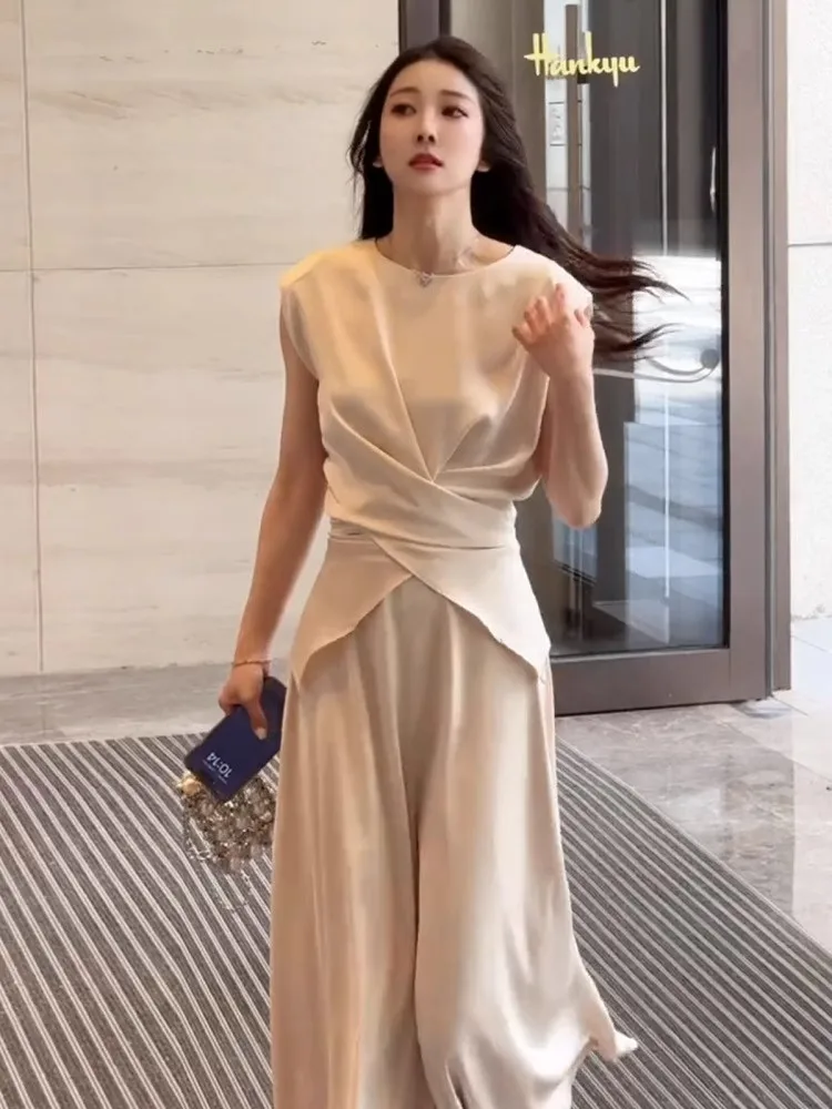طقم توب وتنورة أبيض أنيق بدون أكمام للنساء، طقم مكون من قطعتين بتصميم كوري أنيق لصيف 2025، برقبة دائرية وبنطلون طويل