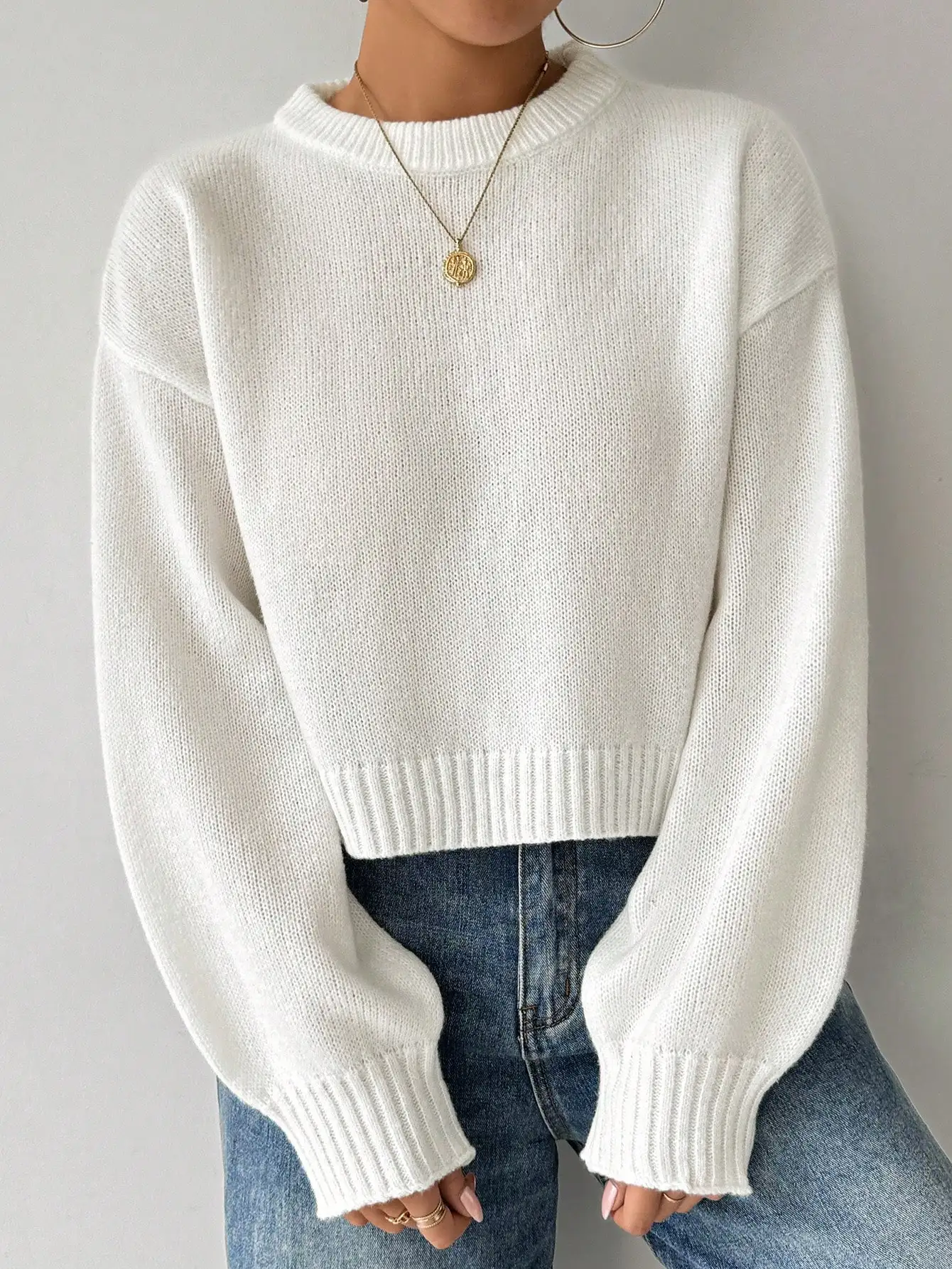 Oliwkowozielony sweter damski z długim rękawem, okrągłym dekoltem, luźny krój, krótka długość.