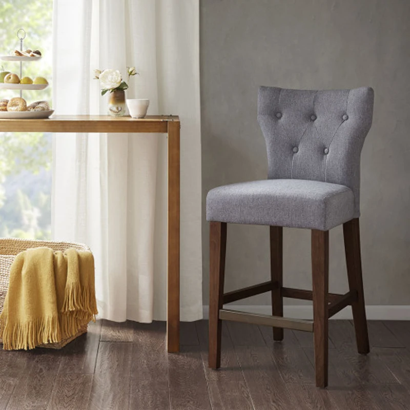 Chic Grey Tufted Back Counter Stool: Dark Brown Wood Legs Contrast, Bronze Kickplate for Durability, Perfect for Dining Space