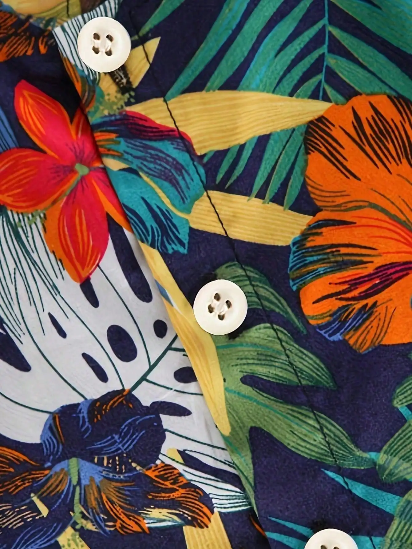 Sommerliches Kinder-Set mit tropischem Blatt- und Blumenmuster, bestehend aus einem kurzärmeligen Hemd mit Stehkragen und passender Shorts. – Detail 3