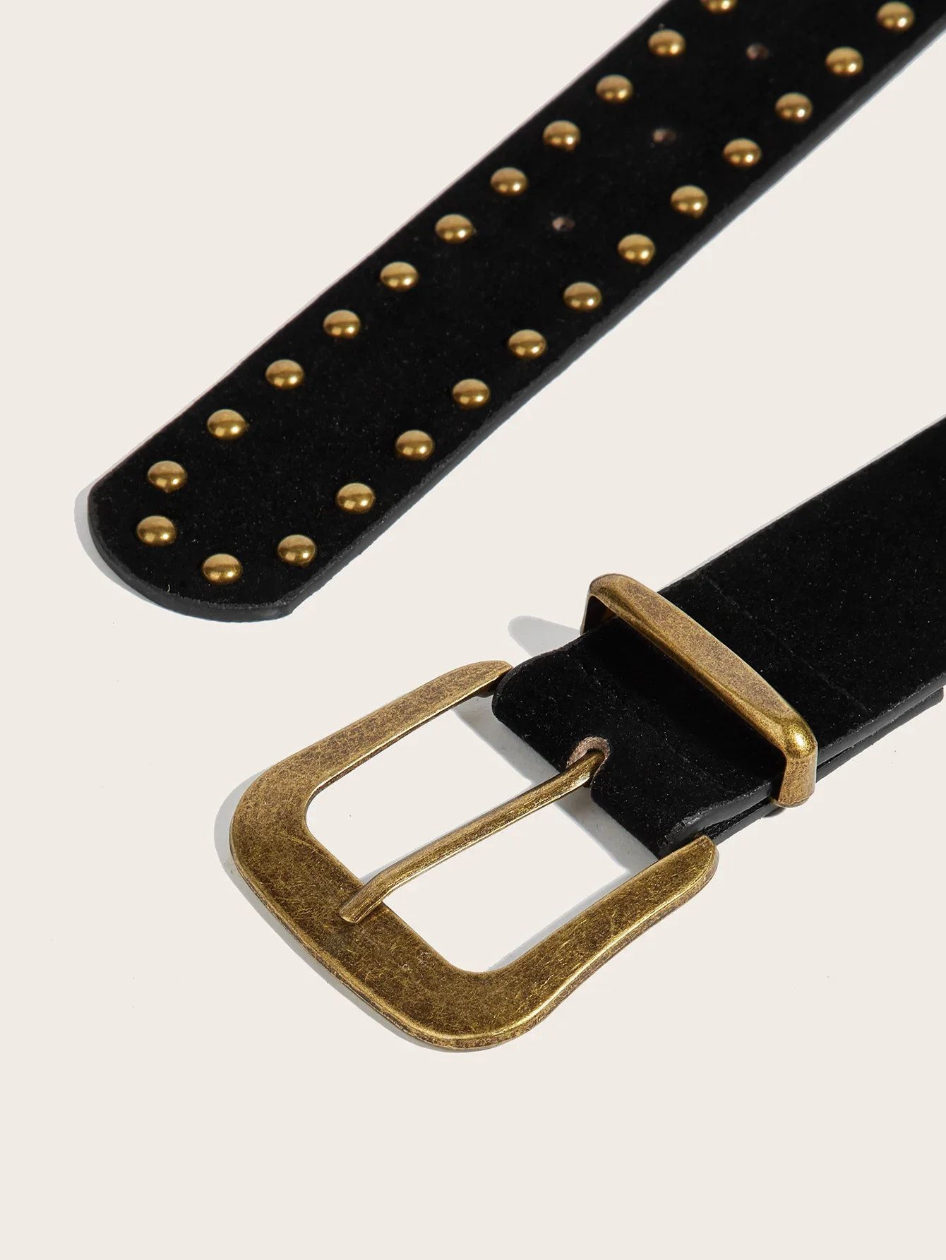 Um cinto unissex, elegante e versátil com rebites e fivelas.