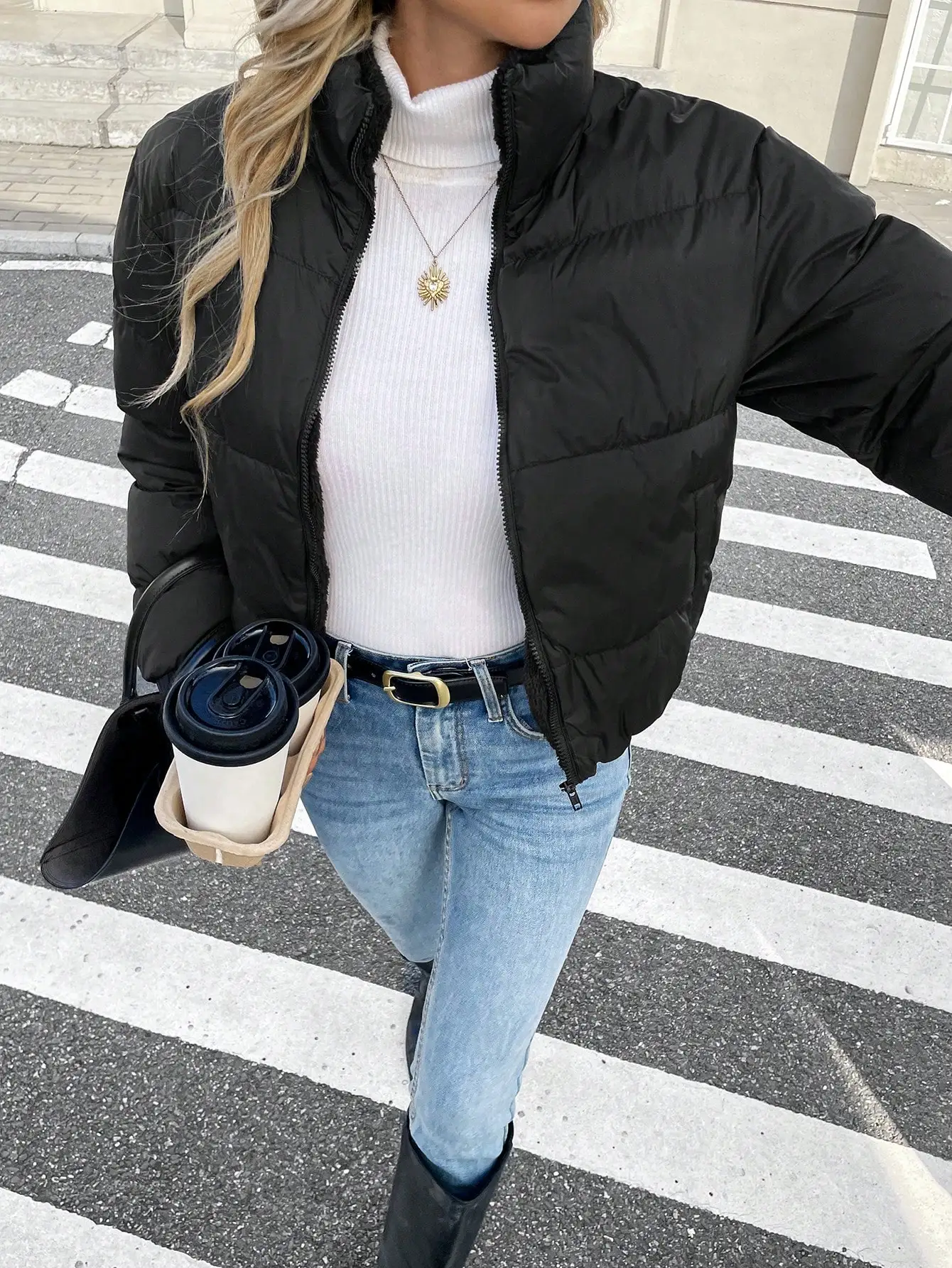 Damska czarna krótka kurtka bomberka puchowa ze stójką i zapinana na zamek z przodu, idealna na zimę.